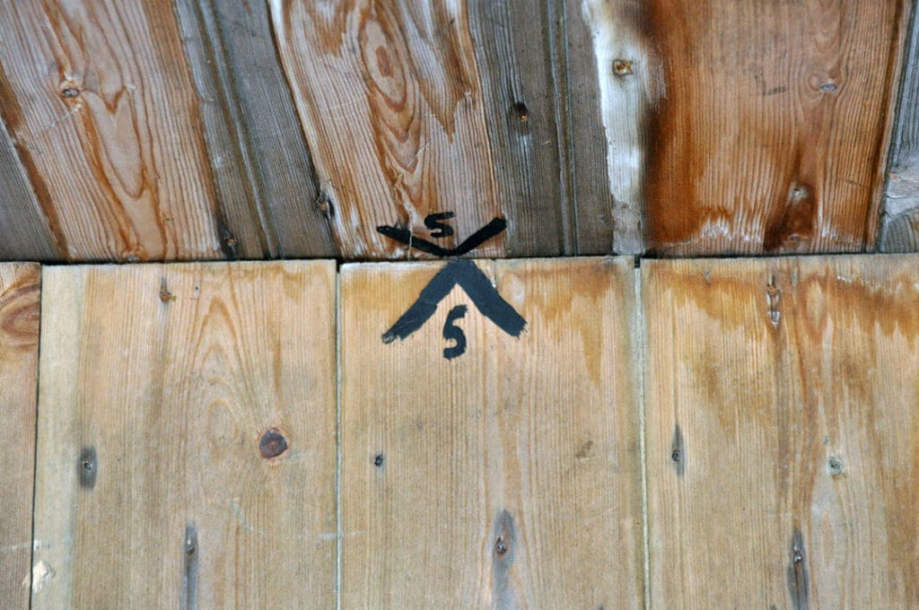 Wooden ceiling with black crossback branding symbol.