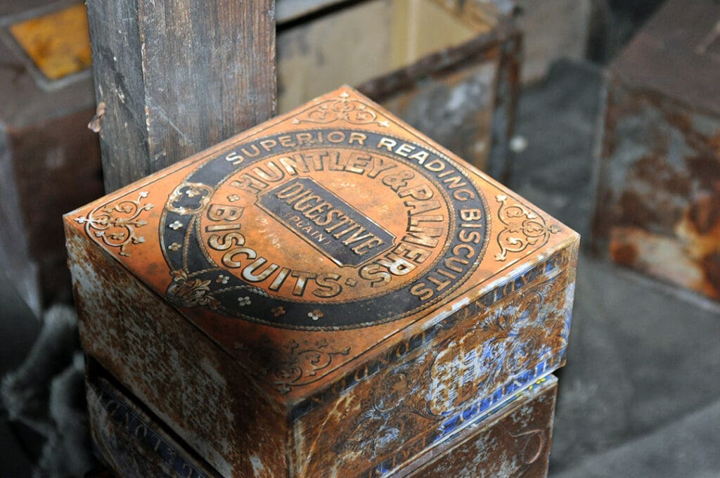 Vintage Huntley & Palmers biscuit tin on shelf.