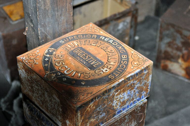 Vintage Huntley & Palmers biscuit tin on shelf.