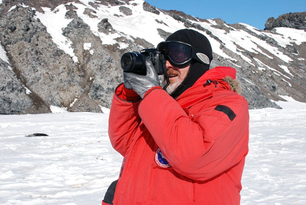 Explorer photographing snowy Antarctic landscape